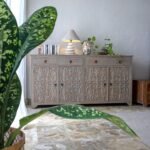 A weathered grey solid wood sideboard with four hand-carved doors and four storage drawers - Modera Furnish.