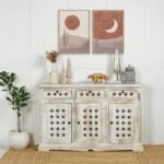 A distressed antique white finish solid sheesham wood sideboard featuring three top drawers and three hand-carved doors with iron rivet detailing - Modera Furnish.