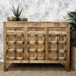 A natural mango wood sideboard featuring three hand-carved doors and three storage drawers with iron hardware - Modera Furnish.