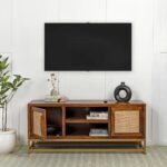 A honey finish solid mango wood TV cabinet featuring two cane doors and a gold metal bottom frame - Modera Furnish.