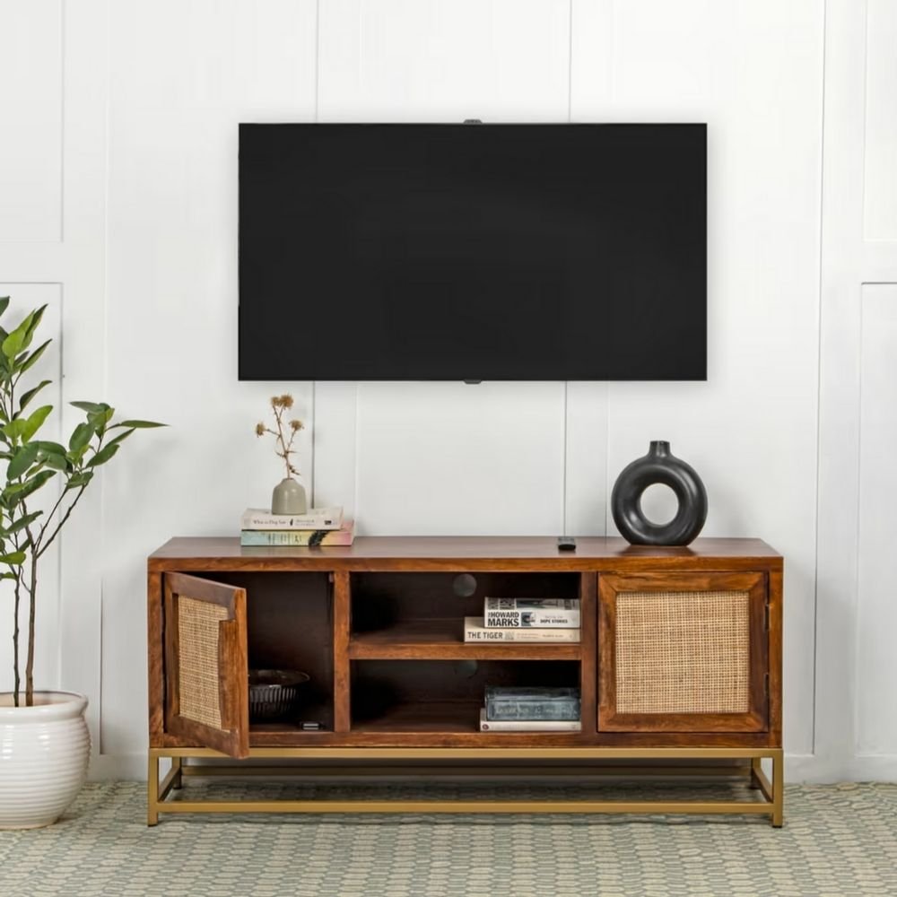 1 A honey finish solid mango wood TV cabinet featuring two cane doors and a gold metal bottom frame - Modera Furnish.
