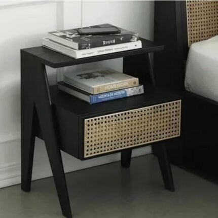 A black solid ash wood nightstand featuring a tiered shelf design and one drawer with a natural rattan panel - Modera Furnish.