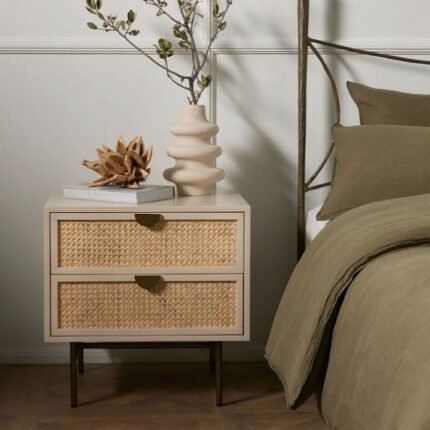 A matte alabaster finish solid wood bedside table featuring two drawers with cane inserts and a stainless steel base - Modera Furnish.