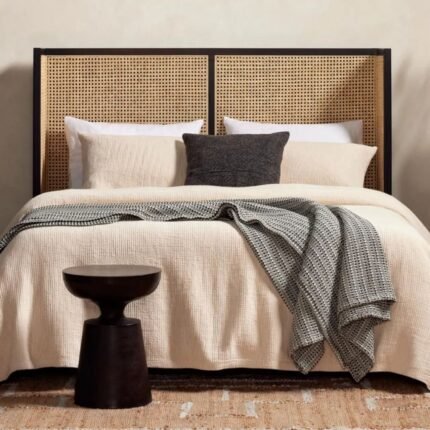 A black solid wood king size bed featuring a wraparound natural rattan cane headboard and tapered legs - Modera Furnish.
