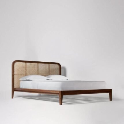 A natural honey solid rosewood bed featuring a rounded headboard with hand-woven cane inlays and a minimalist frame - Modera Furnish.