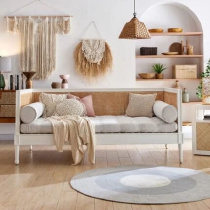 A pristine white solid wood sofa day bed featuring three-sided hand-woven cane panels and elegant turned legs - Modera Furnish.