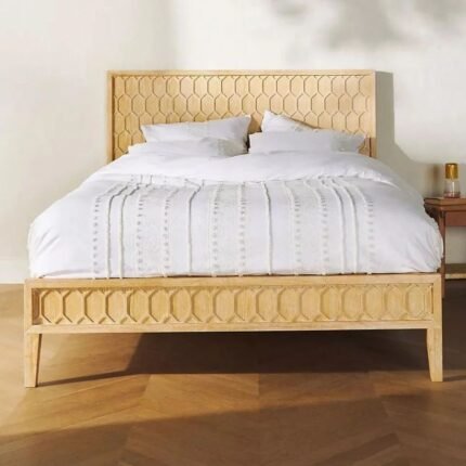 A natural light wood bed featuring an intricate hand-carved geometric trellis pattern on the headboard and footboard - Modera Furnish.
