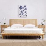 A natural light wood low-profile platform bed with a dual-panel hand-woven cane headboard - Modera Furnish.