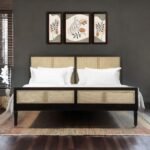 An obsidian black solid wood bed featuring four hand-woven cane panels on the headboard and footboard - Modera Furnish.