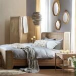 A natural light wood bed with a wrap-around hand-woven cane headboard and footboard - Modera Furnish.