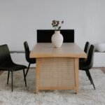 A natural solid wood dining table with an 87-inch rectangular top and cane-inlay trestle legs - Modera Furnish.