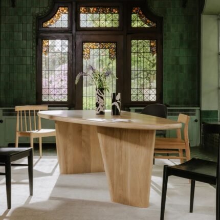 An organic pebble-shaped solid mango wood dining table with a natural finish and dual plinth bases - Modera Furnish.