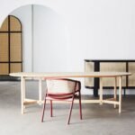 A walnut and black solid mango wood dining chair with a hand-woven cane backrest and tapered legs - Modera Furnish.