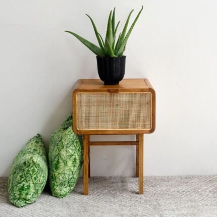 A natural solid wood end table featuring a hand-woven cane drawer front and a structured four-leg base - Modera Furnish.