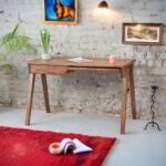 A natural Sheesham solid wood study table featuring a linear architectural top and tapered angled legs - Modera Furnish.