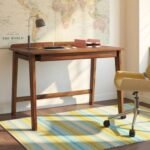 A natural Sheesham solid wood study table in a teak finish featuring a partitioned long drawer and tapered legs - Modera Furnish.