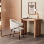 A natural solid wood study table featuring a pill-shaped top and a fluted pedestal base with gold accents - Modera Furnish.