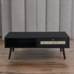 A black finish solid wood coffee table featuring a hand-woven rattan drawer front and a minimalist 110 cm rectangular profile - Modera Furnish.