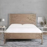 A neutral beige solid wood king-size bed featuring intricate hand-carved floral branch motifs on the headboard - Modera Furnish.