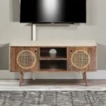 A natural finish mango wood TV unit with two cane-inlay doors and central open shelving - Modera Furnish.