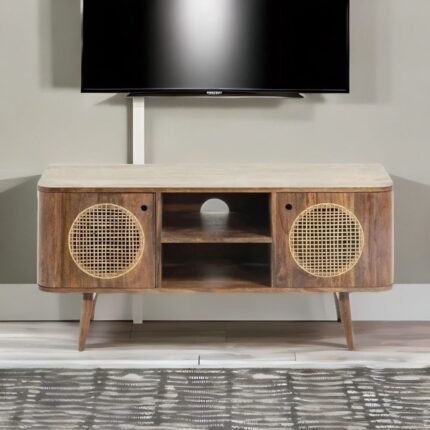 A natural finish mango wood TV unit with two cane-inlay doors and central open shelving - Modera Furnish.