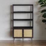 A black solid wood bookshelf with three open shelves and two natural cane doors - Modera Furnish.