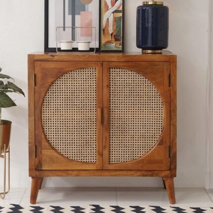 A warm brown solid mango wood cabinet featuring two doors with circular woven cane inlays and internal shelving - Modera Furnish.