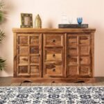A warm honey sheesham wood sideboard featuring hand-carved elephant door panels and three central storage drawers - Modera Furnish.