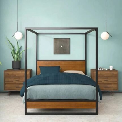 A black industrial carbon steel 4-poster bed frame featuring solid wood headboard panels and a reinforced slat system - Modera Furnish.