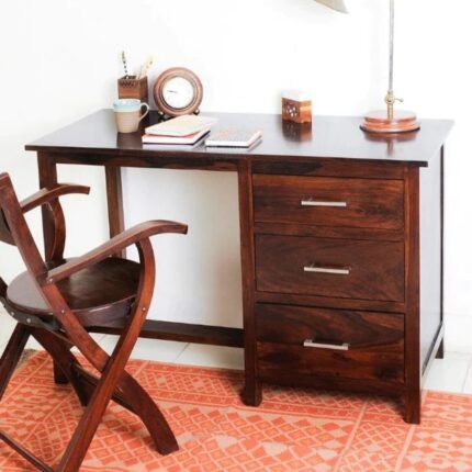 A sophisticated natural finish solid mango wood study table featuring a three-drawer storage pedestal and a minimalist architectural silhouette - Modera Furnish.