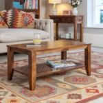 A 36-inch honey gloss solid Sheesham wood coffee table featuring a hand-carved jali lower storage shelf, tapered legs, and rich natural grain - Modera Furnish.