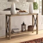 A 46-inch weathered brown wood console table featuring an open lower shelf, matte black metal X-bracing, and industrial corner hardware - Modera Furnish.