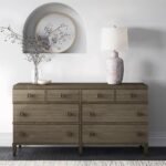 A long dark brown solid wood chest of eight drawers with small square bronze handles in a modern minimalist room - Modera Furnish