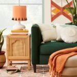 A natural finish solid wood bedside table featuring a single door with an arched rattan panel and gold hardware - Modera Furnish.