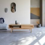A natural honey solid rosewood coffee table featuring a hand-woven cane drawer and an open storage cubby - Modera Furnish.