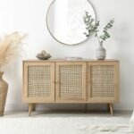A natural light wood sideboard featuring three hand-woven rattan doors and tapered legs - Modera Furnish.
