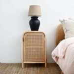 A natural solid wood bedside table featuring hand-woven cane side panels and two open storage shelves - Modera Furnish.