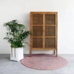 A natural solid wood storage unit cabinet featuring two cane-inlay doors with an internal wardrobe rail and three shelves - Modera Furnish.