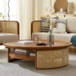 A round amber-colored solid wood coffee table with a curved rattan storage shelf - Modera Furnish.