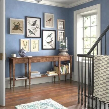 An extra-long 76-inch solid wood console table in a deep umber finish with six legs and a lower display shelf - Modera Furnish.