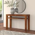 A modern minimalist brown solid wood console table with a thick bridge-style frame in a bright living room - Modera Furnish