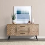 A 65-inch solid acacia wood sideboard cabinet featuring a herringbone-patterned door design, three central drawers, and a brownish beige finish - Modera Furnish.