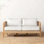 A teak finish solid wood 2 seater sofa featuring hand-woven rattan side panels and white cushions - Modera Furnish.