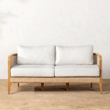 A teak finish solid wood 2 seater sofa featuring hand-woven rattan side panels and white cushions - Modera Furnish.