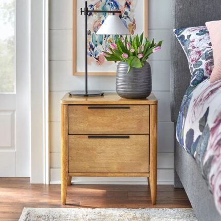 A warm brown solid wood bedside table featuring two drawers with sleek black handles and a hand-stained finish - Modera Furnish.