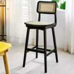 A black solid ash wood counter stool featuring a hand-woven natural rattan seat and backrest - Modera Furnish.