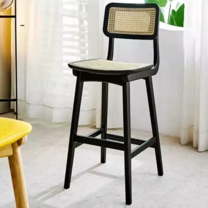 A black solid ash wood counter stool featuring a hand-woven natural rattan seat and backrest - Modera Furnish.