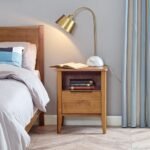 A warm brown solid wood nightstand featuring a single drawer with a black handle and an open storage shelf on tapered legs - Modera Furnish.