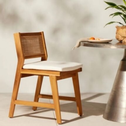 A natural finish solid wood dining chair featuring a hand-woven cane backrest and a white seat cushion - Modera Furnish.